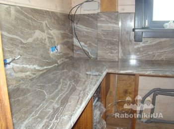 Столешница из мрамора, мойка и облицованная камнем стена