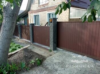 Автоматизовані ворота і секції паркану, зашиті ламелями "Ранчо" вертикально.