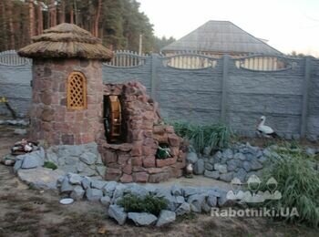 Штучний фонтан з декоративним млином і баштою з бутового каменю