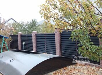 Дерев'яний паркан з колонами з кирпича