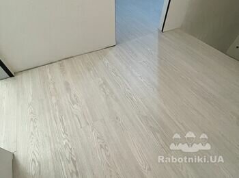 Після. Єдиний масив ламінату на три кімнати з передпокоєм (сходовою кліткою) з примиканням до плитки в санвузлі.