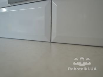 Плитка находит на столешницу, зазор загерметизирован силиконом в цвет замазки. Вибрации столешницы прекрасно гасятся.