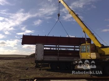 Выгрузка элементов металлического каркаса здания.