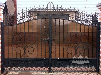 Металлические распашные ворота решетчатого типа с поликарбонатом, коваными элементами и вставкой металла внизу.