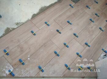 Процесс укладки плитки на балконе с использованием СВП по согласованной зараннее с заказчиком раскладке.