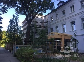 Устройство утепления фасада старого здания с декорированными элементами.