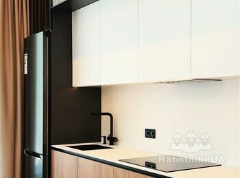 Кухня в Unit.City Київ фасади білі верхні та нижні - під дерево, чорні антресолі під стелею