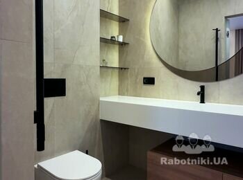 Санвузол з великоформатною плиткою, круглим дзеркалом із підсвіткою і білим литим умивальником
