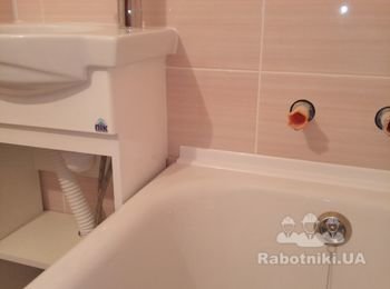 Уложена керамическая плитка, установлен умывальник с тумбой, установлен палстиковый уголок "ванна-стена", герметизация силиконом примыкания умывальник-стена, установлен смеситель и сифон.