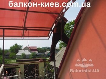 Переходим на крышу здания для закрепления поликарбоната по стальному каркасу со стороны дома. На внешней стороне кровли видна страховочная веревка которая предохраняет лист от разрушения при порывах ветра. Это самый опасный враг - ветер. Вырывает незакреплённый поликарбонат "на раз" Фото сделано с террасы.