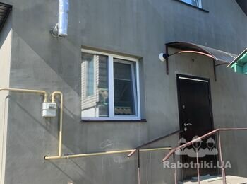 Штукатурка фасаду будинку, облицовка по низу каменем плоским.