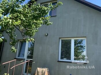 Штукатурка фасаду будинку, облицовка по низу каменем плоским.