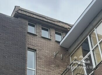 Кладка фронтону на фасаді офісного приміщення з облицювальної цегли